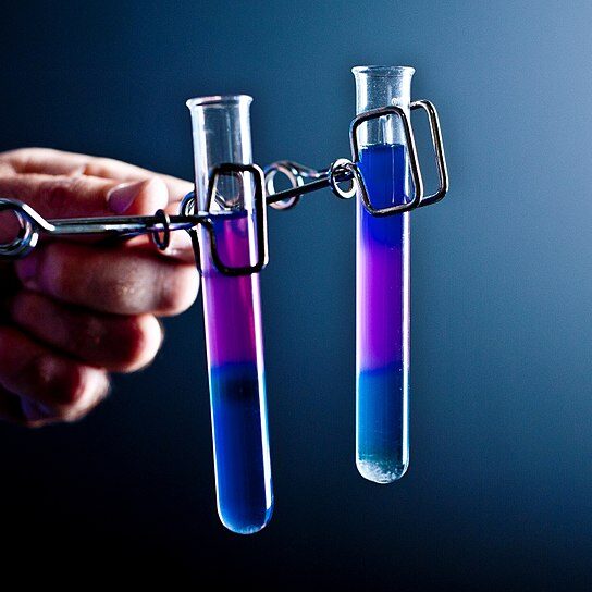 Two_small_test_tubes_held_in_spring_clamps