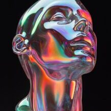 A glass sculpture of a person's head on a black background